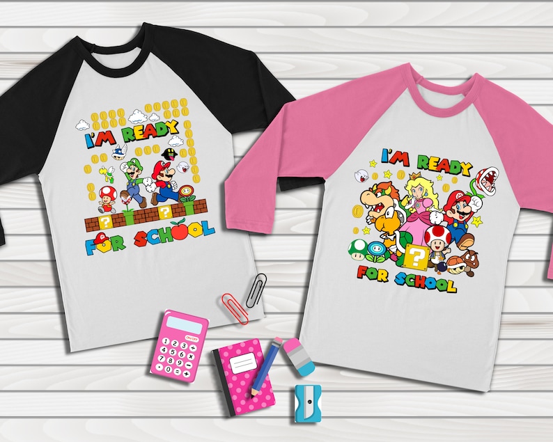 Puede incluir: Dos camisetas de b&eacute;isbol blancas y negras con una camiseta de b&eacute;isbol rosa y negra. Las camisetas tienen el texto "I'm Ready for School" y presentan personajes del videojuego Super Mario Bros.