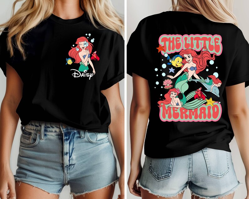 May include: Black t-shirt featuring a colorful graphic of Ariel from The Little Mermaid. The front design includes Ariel and the word "Daisy". The back of the shirt has a larger design with Ariel, Flounder, Sebastian, and the words "The Little Mermaid".