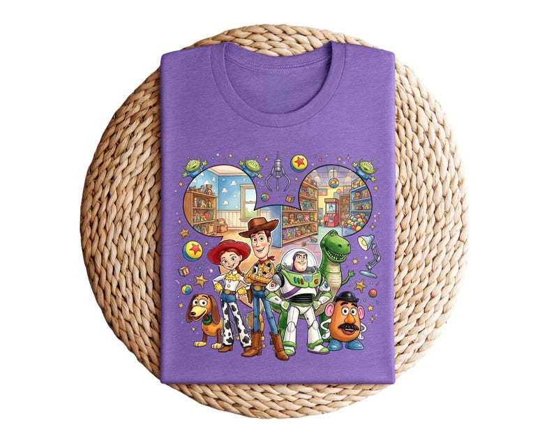 Pode incluir: Uma camiseta roxa com um gr&aacute;fico colorido dos personagens de Toy Story. O design apresenta Woody, Buzz Lightyear, Jessie, Rex, Sr. Batata, Slinky Dog e outros elementos do filme de anima&ccedil;&atilde;o.