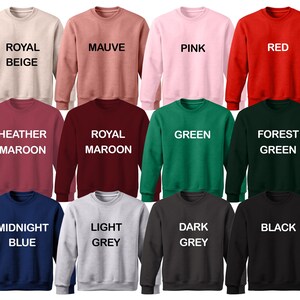 Puede incluir: Un conjunto de 12 sudaderas con cuello redondo en varios colores, incluyendo beige real, malva, rosa, rojo, granate jaspeado, granate real, verde, verde bosque, azul medianoche, gris claro, gris oscuro y negro. Cada sudadera tiene un color diferente y una etiqueta de texto con el nombre del color.
