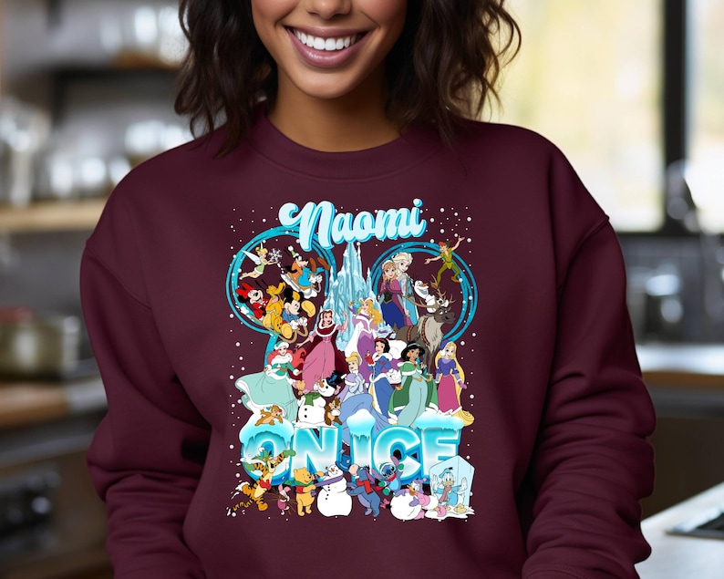 Puede incluir: Sudadera color burdeos con un gr&aacute;fico de personajes de Disney de Frozen y otras pel&iacute;culas de Disney. El texto "Naomi" y "On Ice" est&aacute; impreso en la sudadera.