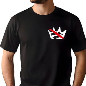 Peut inclure: T-shirt noir avec un motif de couronne blanche barr&eacute;e d'une barre rouge. Le motif est situ&eacute; sur la poitrine gauche. Le t-shirt a des manches courtes et un col rond.