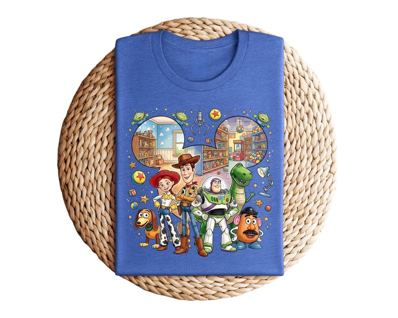 Pode incluir: Uma camiseta azul com um gr&aacute;fico colorido dos personagens de Toy Story. O design inclui Woody, Buzz Lightyear, Jessie, Rex, Sr. Batata, Slinky Dog e cenas do filme, para um visual divertido.