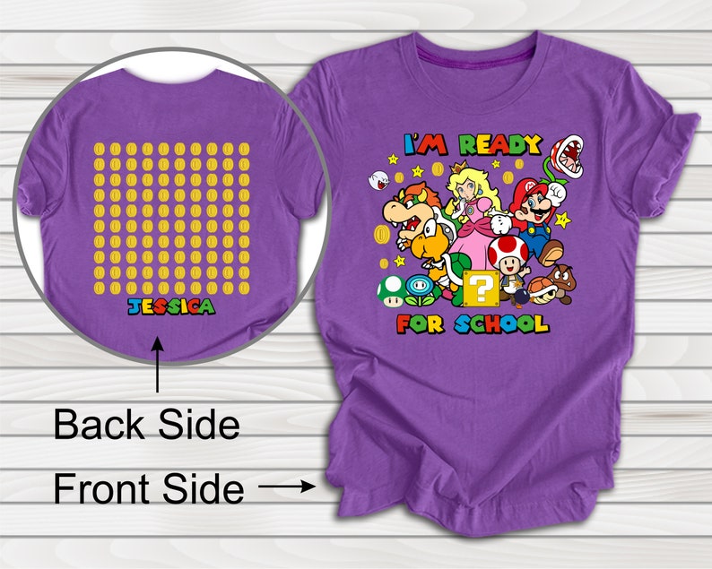 Puede incluir: Camiseta morada con un gr&aacute;fico de personajes de Mario y el texto "I'm Ready For School". La parte posterior de la camiseta tiene una cuadr&iacute;cula de monedas de oro con el nombre "Jessica" impreso debajo.