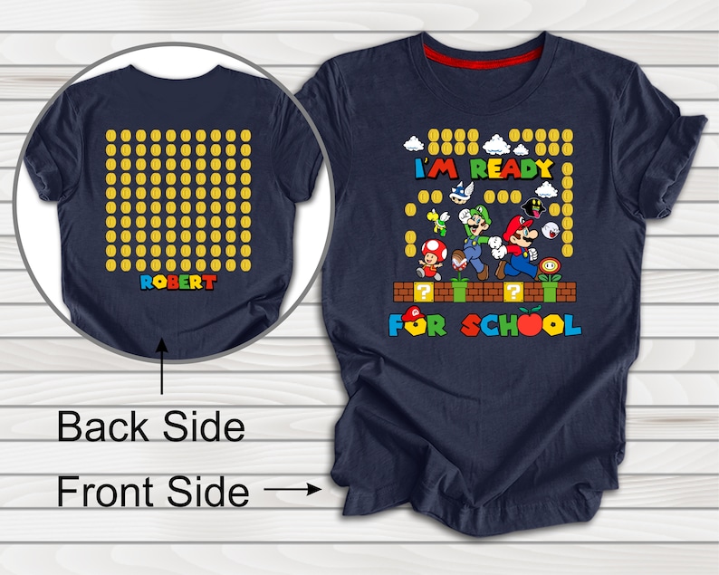 Puede incluir: Una camiseta azul marino con un gr&aacute;fico de Mario y sus amigos del videojuego Super Mario Bros. El gr&aacute;fico incluye el texto "I'm Ready For School". La parte posterior de la camiseta tiene un patr&oacute;n de monedas de oro con el nombre "ROBERT" impreso en letras de colores.