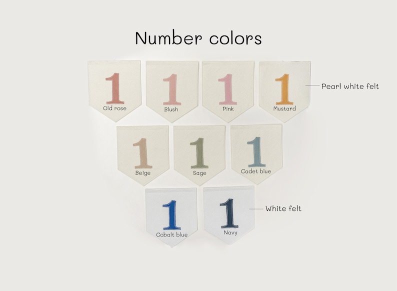 May include: A set of felt number ones in various colors, including old rose, blush, pink, mustard, beige, sage, cadet blue, cobalt blue, and navy. The felt pieces are arranged in rows on a white background.