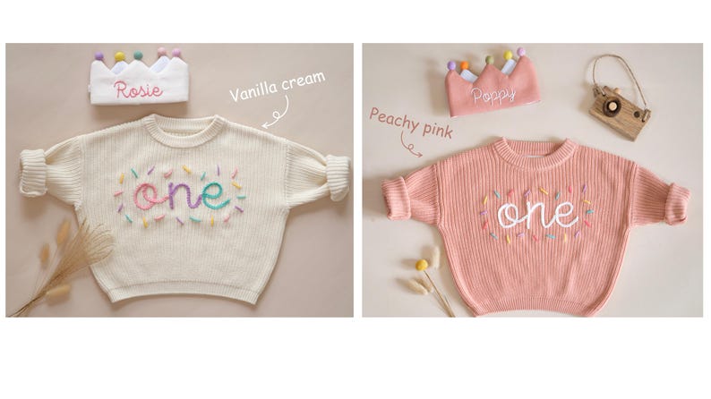 May include: Two knitted baby sweaters with the word "one" embroidered on the front in colorful thread. The sweaters are in vanilla cream and peachy pink colors. Each sweater is paired with a crown headband, one with the name "Rosie" and the other with the name "Poppy".