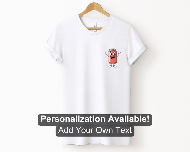 May include: A white t-shirt with a cartoon image of a red can with a smiling face and arms and legs. The text 'Personalization Available! Add Your Own Text' is below the image.