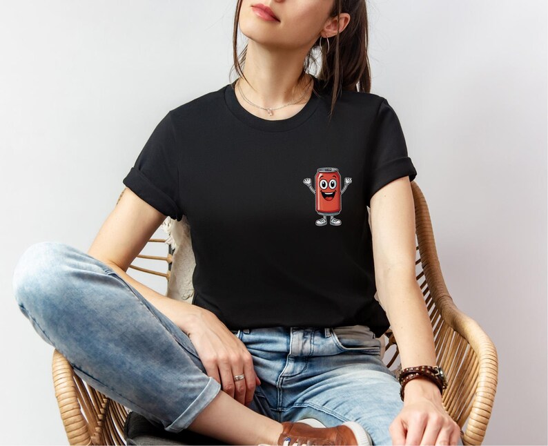 May include: A black t-shirt with a red cartoon can with a smiling face and arms and legs.