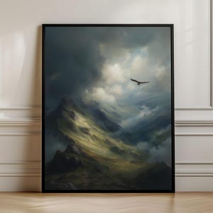 Pode incluir: Uma impressão de arte de parede emoldurada retratando uma paisagem montanhosa dramática sob um céu tempestuoso e nublado. Um pássaro solitário voa na atmosfera escura e sombria, com raios de sol iluminando os picos verdes e escarpados.