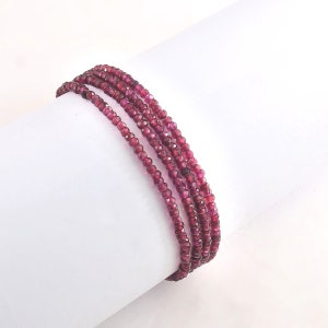 May include: A multi-strand bracelet made of small, faceted, dark pink beads.