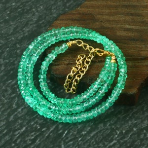 May include: A green emerald gemstone necklace with a gold chain clasp. The necklace is made of small, faceted beads and is approximately 18 inches long.