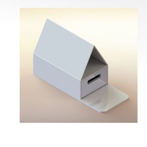 May include: A white cardboard box shaped like a house with a drawer on the front. The box is open and the drawer is pulled out.