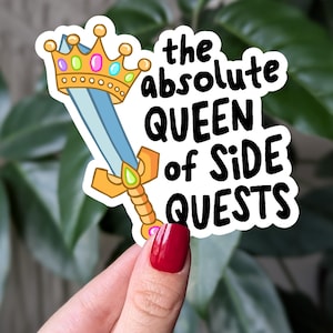 May include: A sticker with a cartoon sword and crown, and the text "the absolute QUEEN of SIDE QUESTS".