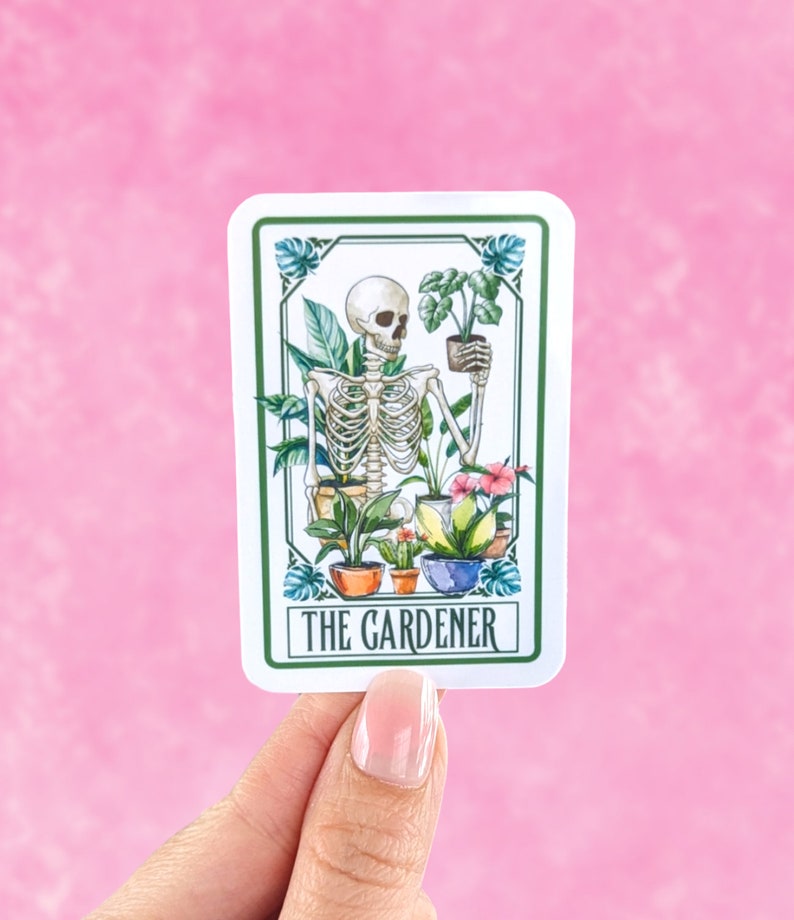 Puede incluir: Una pegatina blanca con un borde verde que muestra un esqueleto sosteniendo una planta en maceta. El esqueleto est&aacute; rodeado de otras plantas en maceta y flores. El texto "THE GARDENER" est&aacute; impreso en la parte inferior de la pegatina.