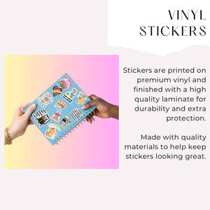 May include: A light blue spiral-bound notebook covered in various colorful vinyl stickers featuring cartoon animals, food, and text. The stickers include designs of a cat, a rainbow, a bus, and phrases like "WTF AM I DOING WITH MY LIVES?" and "ALL ABOARD."