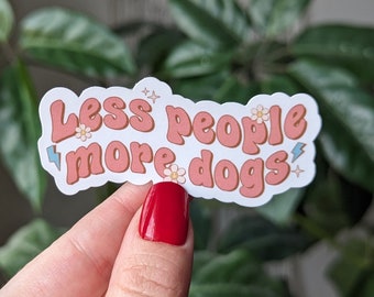 May include: A white sticker with pink text that reads "Less people more dogs" with small flower and lightning bolt accents.