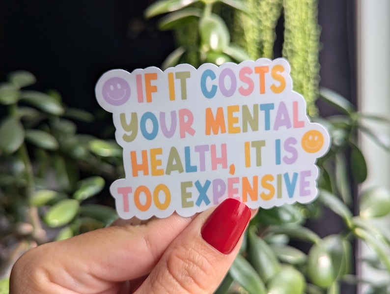 May include: A white sticker with a colorful rainbow design and the text "IF IT COSTS YOUR MENTAL HEALTH, IT IS TOO EXPENSIVE".