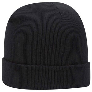 Op de afbeelding: Een effen zwarte beanie-muts met een omgeslagen rand. De hoed is gemaakt van een geribbelde gebreide stof. Deze wintermuts is een veelzijdig accessoire voor koud weer.