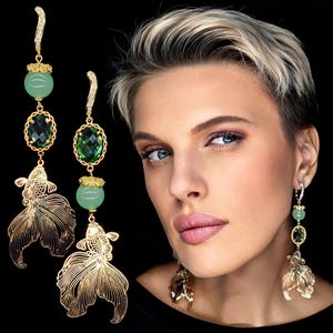 Può includere: Orecchini pendenti in oro con pietra preziosa verde e perle di giada, con un design dettagliato di un pesce d'oro.