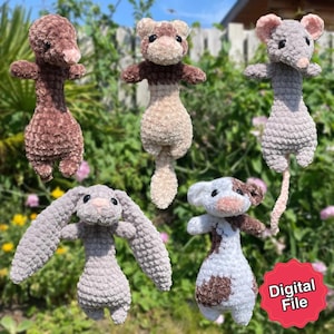 Könnte beinhalten: Eine Sammlung handgefertigter Häkeltierspielzeuge in verschiedenen Farben. Die Spielzeuge umfassen ein braunes Frettchen, eine graue Maus, ein graues Kaninchen, eine braune und weiße Kuh und ein braunes Tier. Die Spielzeuge werden vor einem grünen Hintergrund präsentiert. Das Bild enthält einen roten Aufkleber mit der Aufschrift "Digital File".