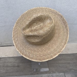 May include: A light brown woven straw hat with a wide brim.