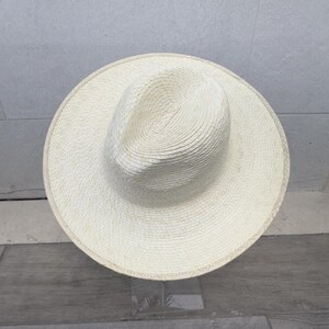 May include: A white straw hat with a wide brim and a woven texture.