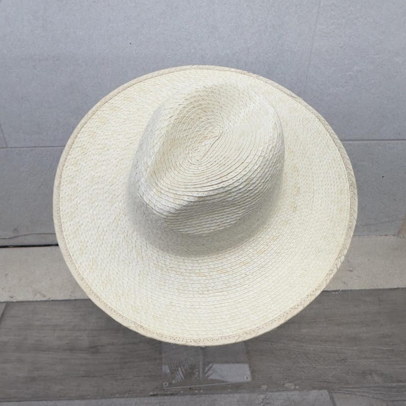 May include: A white straw hat with a wide brim and a woven texture.