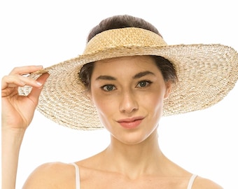 May include: A wide-brimmed sun hat made of woven straw. The hat features a large, circular brim and a smaller, curved visor. The natural beige color of the straw provides a neutral tone. The hat is designed to provide shade from the sun.