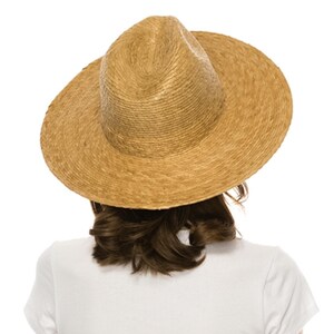 May include: A wide-brimmed straw hat with a brown color. The hat is made of woven straw and has a slightly rounded crown.