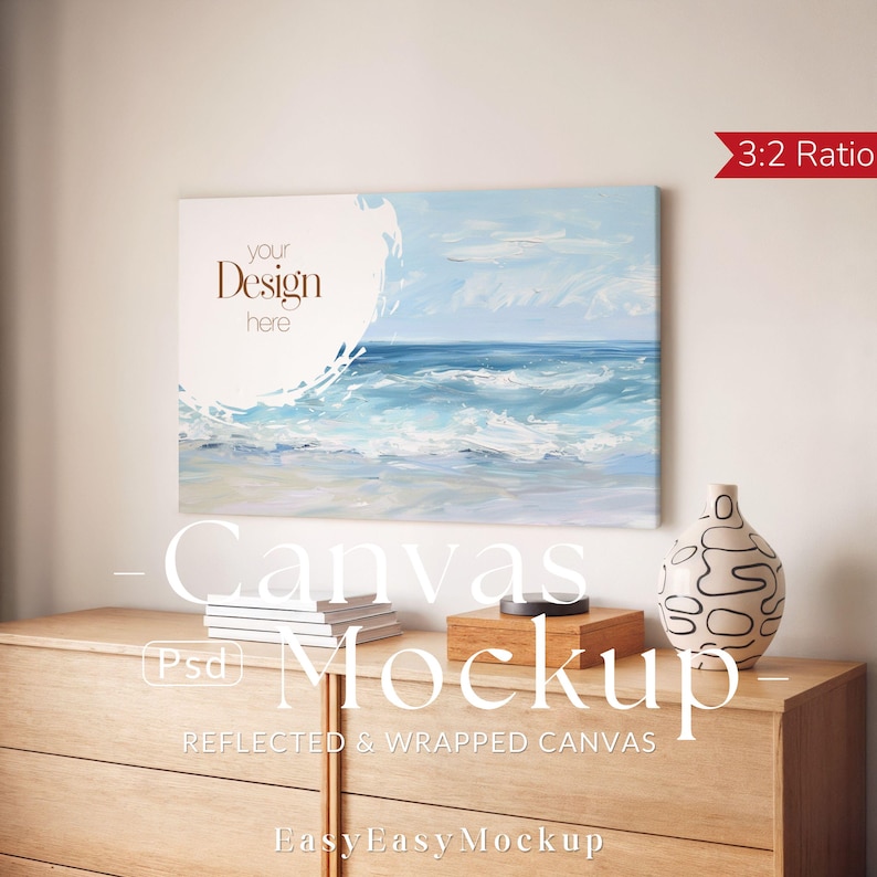 Puede incluir: Maqueta de lienzo con una pintura de paisaje marino en tonos azules y blancos. El lienzo se muestra sobre una c&oacute;moda de madera, junto a un jarr&oacute;n decorativo, libros y una caja de madera. El texto "your Design here" est&aacute; en el lienzo. La imagen tambi&eacute;n incluye el texto "Canvas Mockup".