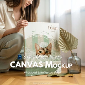 May include: A canvas mockup featuring a watercolor illustration of a cat peeking through bubbles. The canvas has the text "your Design here" and "CANVAS Mockup" with "Wrapped & Reflected Edge" below. The image also includes a decorative plant and a glass vase.