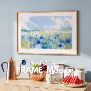 May include: A framed watercolor painting of a field of blue flowers and tall grass. The frame is light-colored wood. The words "FRAME Mockup" are displayed below the frame, along with "JPG-PSD Files & Tutorial".