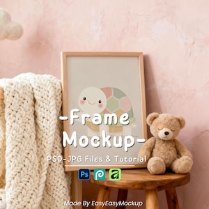 May include: A framed print with a turtle illustration in a nursery setting. A teddy bear sits on a wooden stool beside the frame. A cream blanket is draped over a wooden cot. The image has a soft, pastel colour palette.