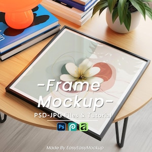 Puede incluir: Maqueta de impresión artística enmarcada en negro con un diseño floral, una flor blanca y formas abstractas en una paleta de colores claros. El texto "-Frame Mockup-" se muestra en la obra de arte. La maqueta está sobre una mesa redonda de madera.