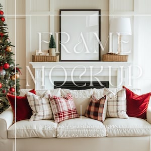 Könnte beinhalten: Ein weißes Sofa mit roten und weißen karierten Kissen und einem roten Samtkissen. Ein gerahmtes Bild hängt über einem Kaminsims mit einem Weihnachtsbaum im Hintergrund.