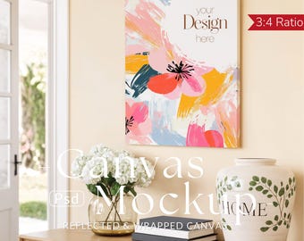 May include: A canvas mockup with a floral design in pink, orange, yellow, and teal. The canvas is rectangular and has the text "your Design here". A vase with the word "HOME" and a bouquet of white flowers are on a wooden surface.
