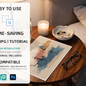 May include: A still-life image featuring a round wooden table with a framed abstract art print. The print depicts a face with blue, peach, and yellow brushstrokes. A lit candle, a small bowl with jewelry, and eyeglasses are also on the table. Text on the left side reads: EASY TO USE, TIME-SAVING, PSD | JPG | TUTORIAL, HIGH RESOLUTION, COMPATIBLE.