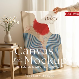 May include: A canvas mockup with a beige backdrop, showcasing a red and blue abstract design. The text "your Design here" is visible. The canvas is propped against a wall, with a small wooden stool and vase of flowers in the foreground.