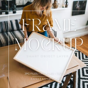 Op de afbeelding: Een witte frame mockup met een houten rand. De frame wordt vastgehouden door een persoon. De tekst "FRAME MOCKUP" is geschreven in een decoratief lettertype boven de frame. De tekst "SMART OBJECT LAYER" is geschreven onder de frame. De tekst "JPG FILES + PSD FILES + TUTORIAL" is geschreven onder de frame. De tekst "EASYEASYMOCKUP" is geschreven onder de frame.