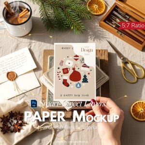 Puede incluir: Una maqueta de papel con temática navideña con una tarjeta de felicitación con ilustraciones festivas. La tarjeta está rodeada de elementos de temporada como palitos de canela, rodajas de naranja secas y agujas de pino. El texto de la tarjeta dice "MERRY C & HAPPY NEW YEAR".