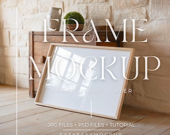 May include: A wooden frame mockup with a white background, sitting on a wooden dresser with a plant in a pot. The text "FRAME MOCKUP" is written in white above the frame, and the text "SMART OBJECT LAYER" is written in white below the frame. The text "JPG FILES + PSD FILES + TUTORIAL" is written in black below the frame, and the text "EASYEASYMOCKUP" is written in black below that.