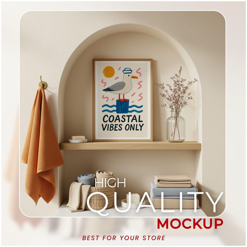 May include: A framed art print with a seagull illustration and the text "Coastal Vibes Only" hangs above a shelf. A folded orange towel hangs on a brass hook. A woven basket and folded linens are below the shelf. A vase of dried flowers is on the shelf.