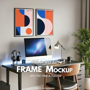 May include: An office scene with a black desk, computer, headphones, and a desk lamp. Two framed abstract art prints are on the wall. The text "FRAME MOCKUP" is displayed on the desk. The art prints feature orange, blue, and pink geometric shapes.