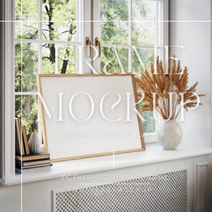 Könnte beinhalten: Ein goldener Rahmen-Mockup mit weißem Hintergrund, der auf einer weißen Fensterbank steht. Der Rahmen befindet sich vor einem Fenster mit Blick auf grüne Bäume. Rechts vom Rahmen stehen getrocknete Blumen in einer weißen Vase. Der Text "FRAME MOCKUP SMART OBJECT LAYER" ist auf dem Bild sichtbar.