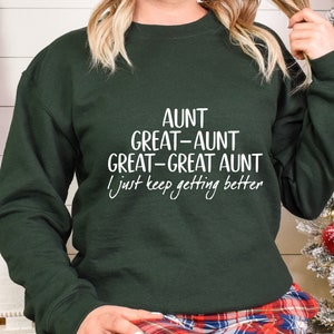 May include: A dark green sweatshirt with white text that reads "Aunt Great-Aunt Great-Great Aunt I just keep getting better".