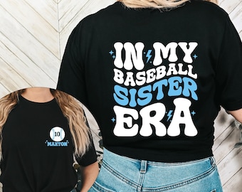 May include: Black t-shirt with white text that reads "In My Baseball Sister Era" with a lightning bolt graphic. The text is in a retro font style.