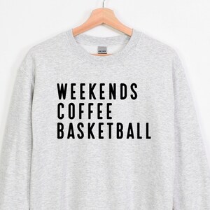 May include: A gray sweatshirt with black text that reads "Weekends Coffee Basketball".
