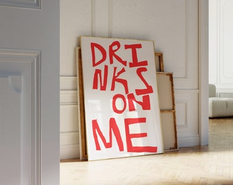 Könnte beinhalten: Ein weißer gerahmter Poster mit den Worten "DRINKS ON ME" in Rot.