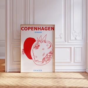 Może przedstawiać: Biały plakat z czerwonym konturem granatu i tekstem "Kopenhaga, Dania, Amager".